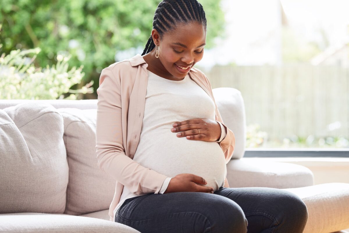 Cropped shot of an attractive young mother to be sitting on the sofa at home.